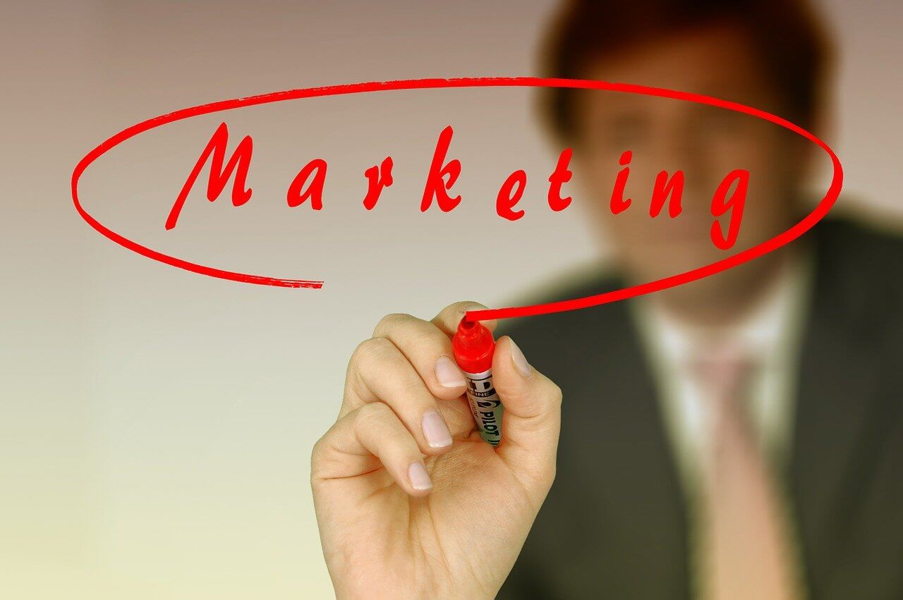 Image of a man writing the word marketing
